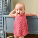 Sandnes Garn Markenname auf einem gestrickten Baby-Kleid in Pink.