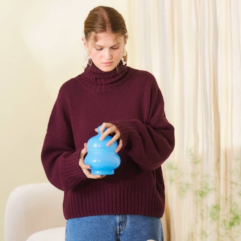 Sandnes Garn Mindy Sweater für mittleres Niveau, Pullover in Burgunderrot, getragen von einer jungen Frau.