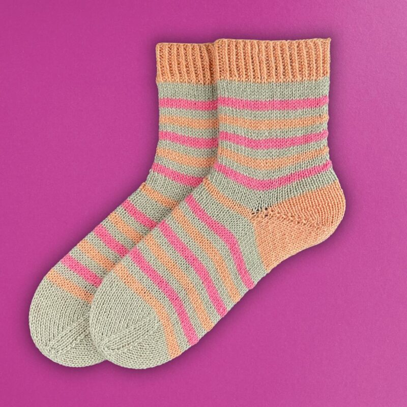 Bunte gestrickte Socken mit Streifen in Pastellfarben, ideal für den Frühling.