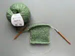 Strickset mit grünem Garn und Anleitung für A-Linien-Pullover 'Tusheti' im Wollke-Shop.